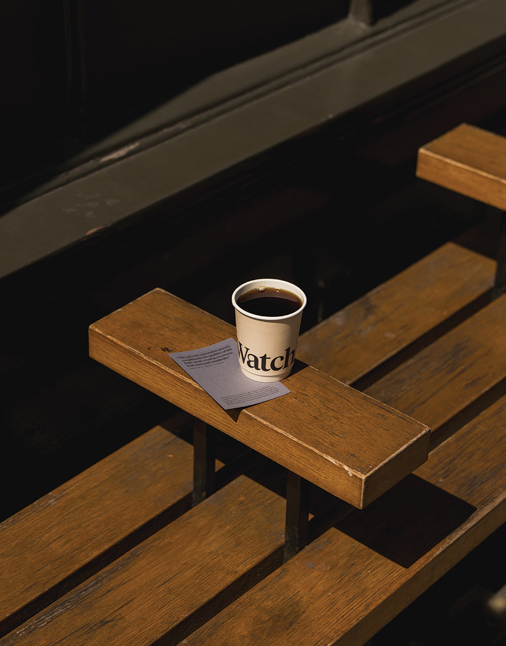 The Lady, Horizons Filter sat on a exterior bench in a takeaway cup with card